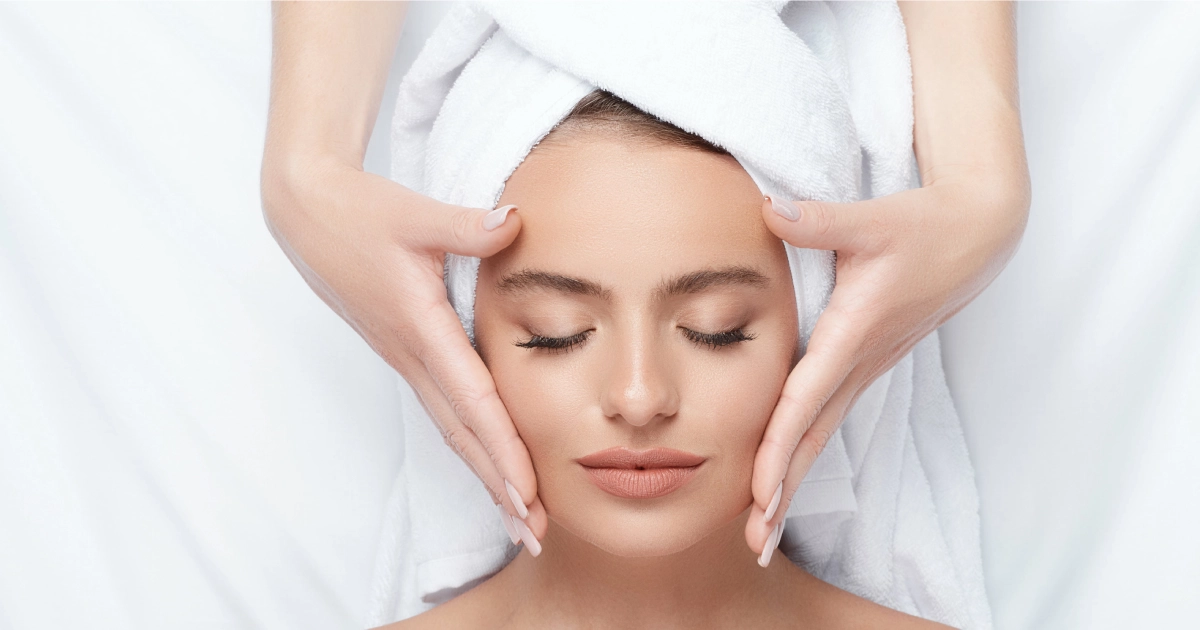 Woman receiving AquaFirme Facial in Orlando, FL, with towel on head and eyes closed